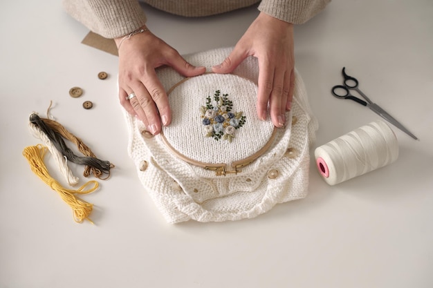 warsztat haftu, dłonie pracujące nad tkaniną